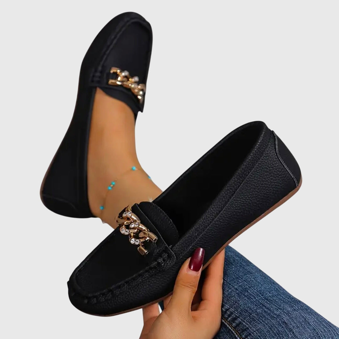Black slip-on loafers with gold chain ornament on the vamp and padded collar.