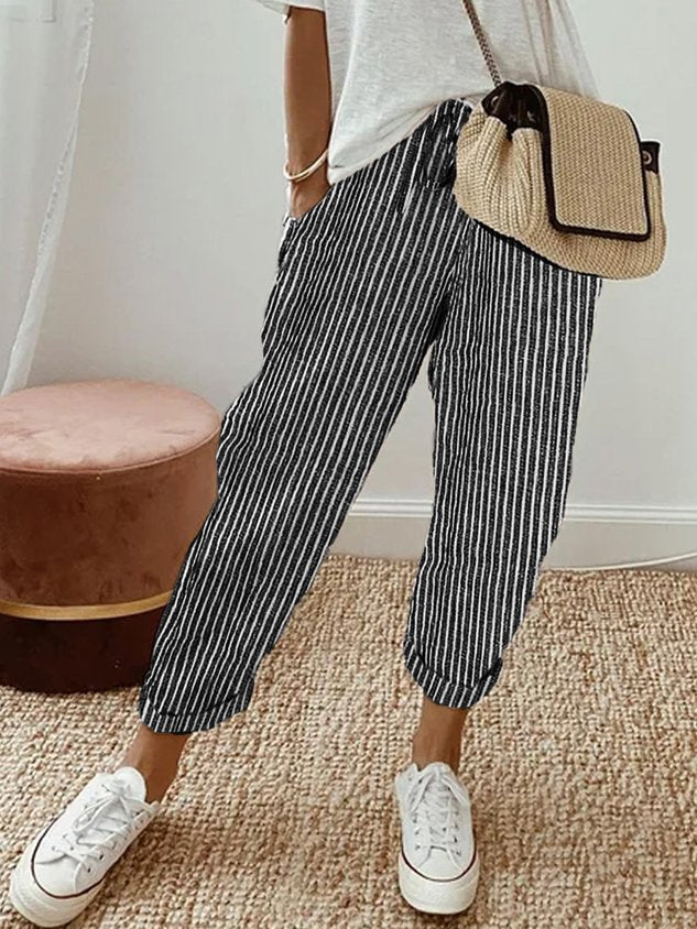 Black striped relaxed drawstring pants with cuffed hem and adjustable waist tie.