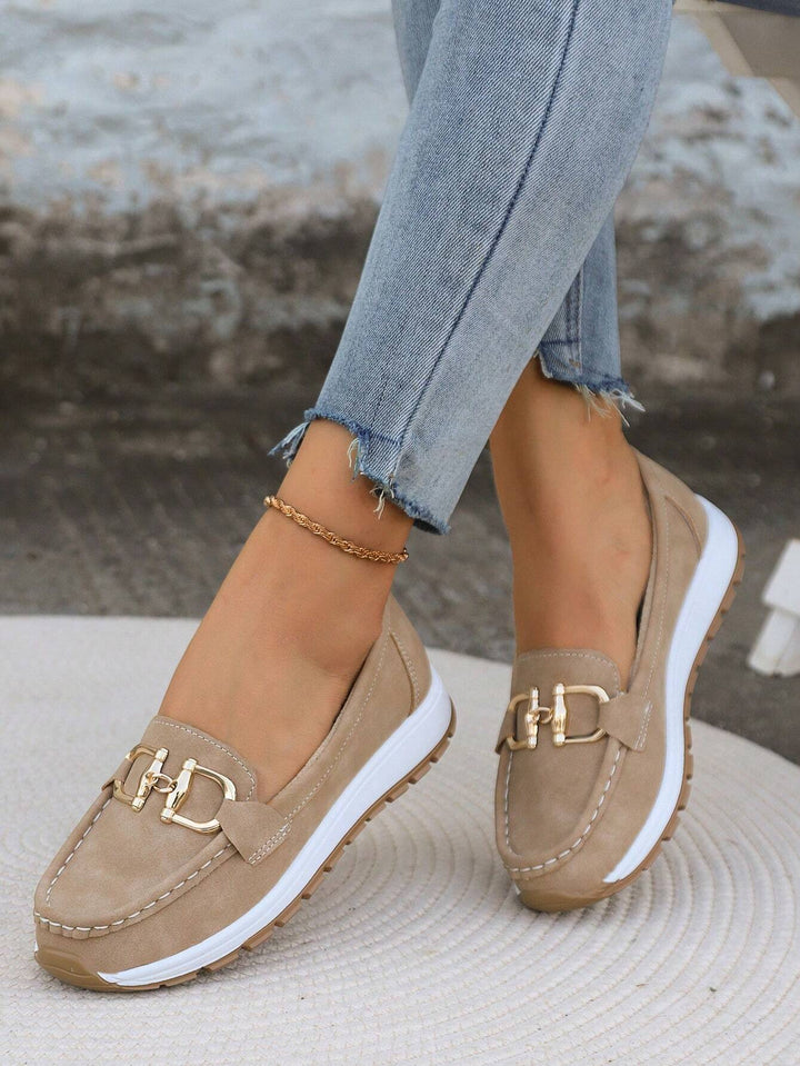 Khaki slip-on loafers with gold chain bar detail, stitched moccasin seams, white sole.