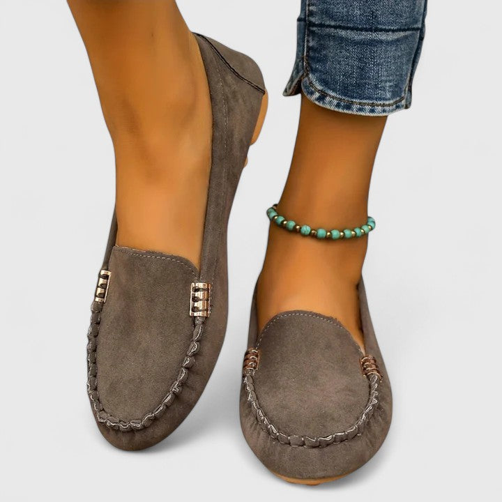 Gray suede slip-on loafers with metal buckle detail and stitched moccasin toe