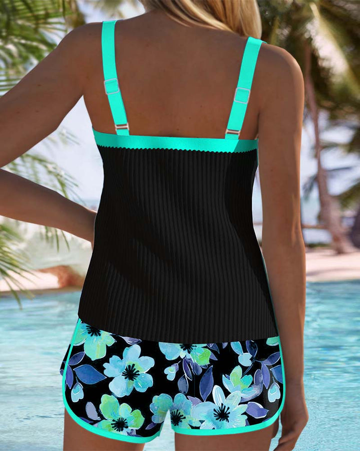Black tummy control tankini with turquoise straps and floral shorts, rear view