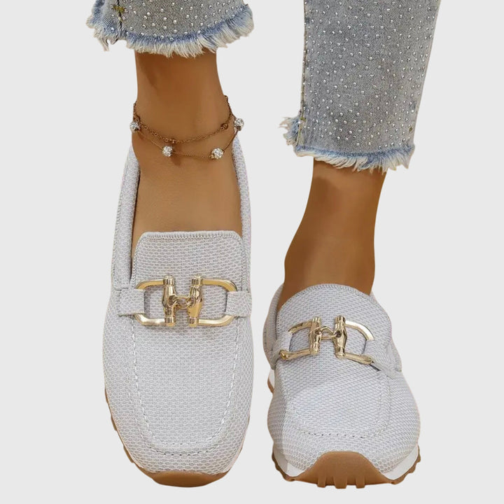 White chain-detail slip-on loafers with gold buckle hardware and rounded toe
