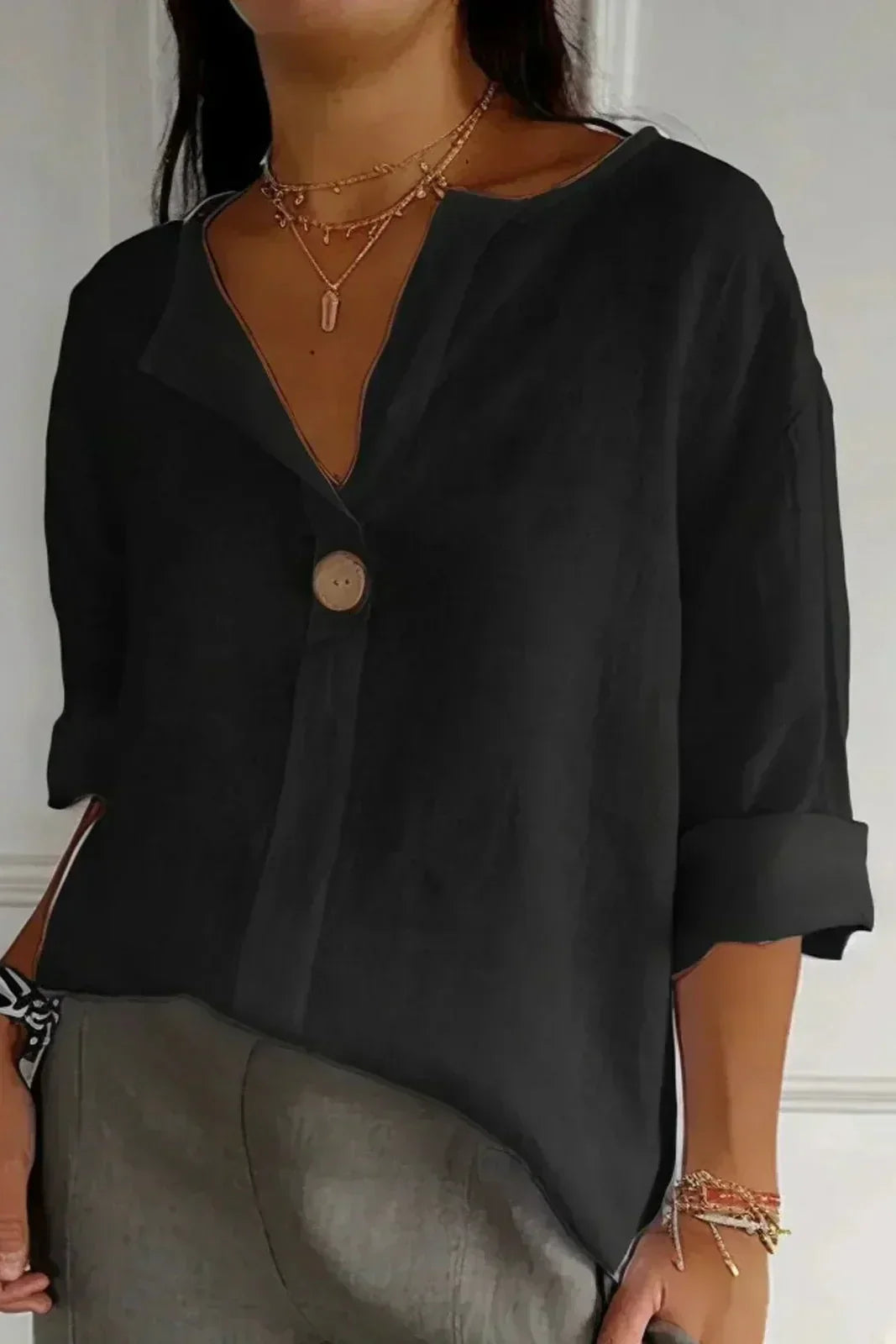 Black minimal button blouse with V-neck, elbow-length sleeves, and round front button