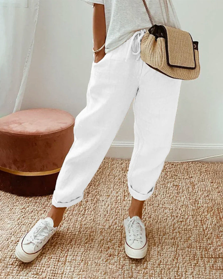 White relaxed drawstring pants with cuffed hem and adjustable waist tie.