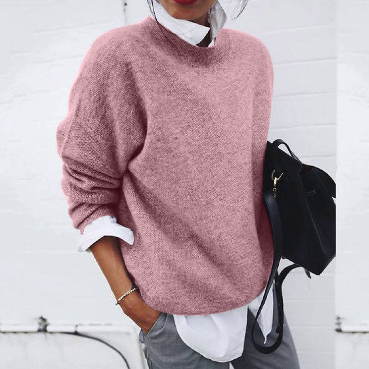 Pink knit crewneck sweater with ribbed neckline and long sleeves.
