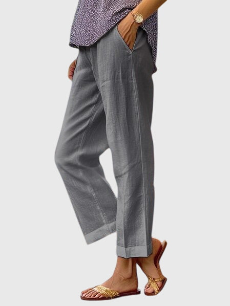 Gray relaxed pants with side pockets and loose straight legs ending at an ankle-length hem
