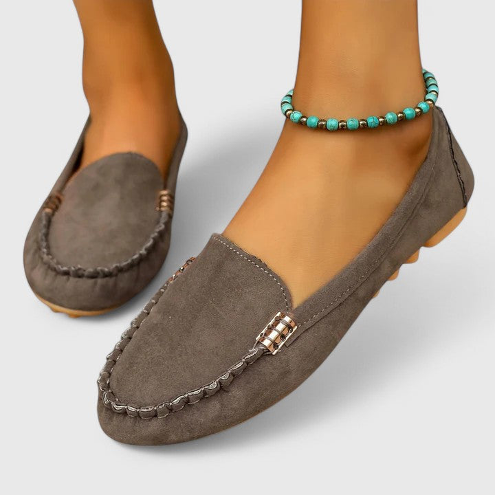 Gray suede slip-on loafers with metal buckle accent and stitched moc toe