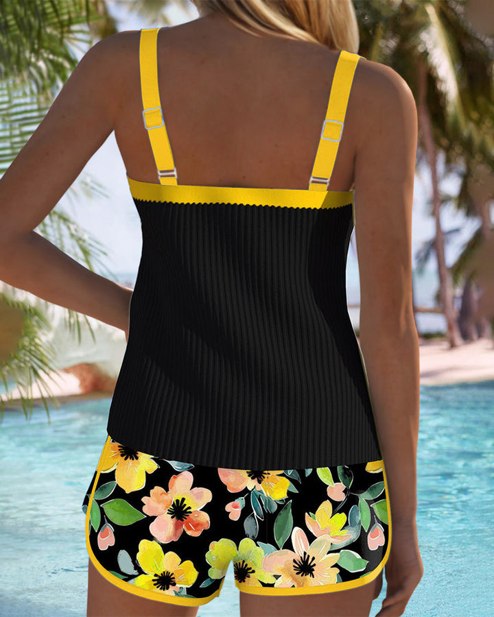 Black tankini set back view with yellow trim straps and floral shorts