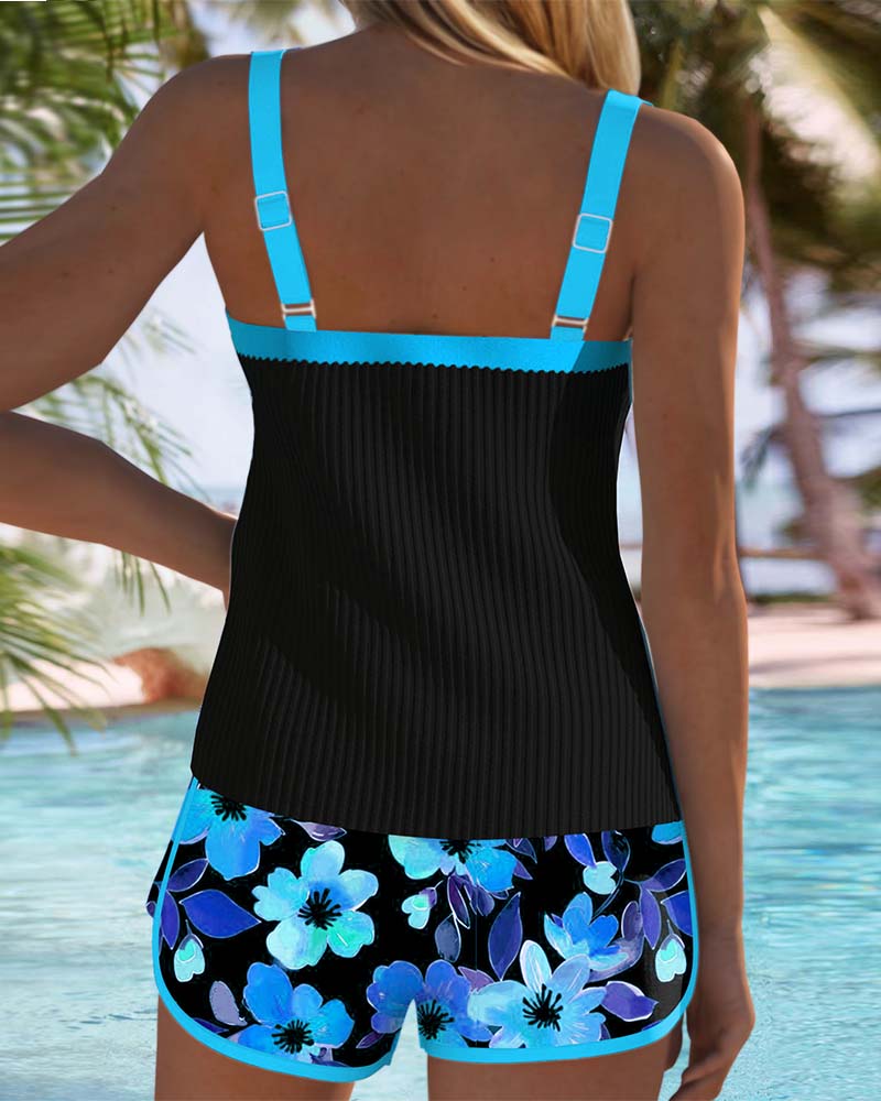 Black tummy control tankini with turquoise back straps and floral shorts, rear
