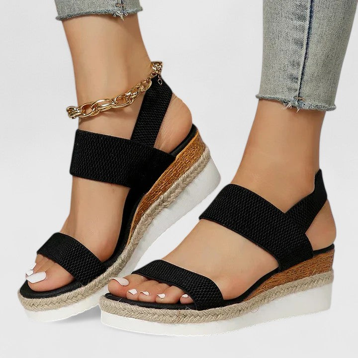 Women’s orthopedic sandals with arch support, black woven straps and gold ankle chain.