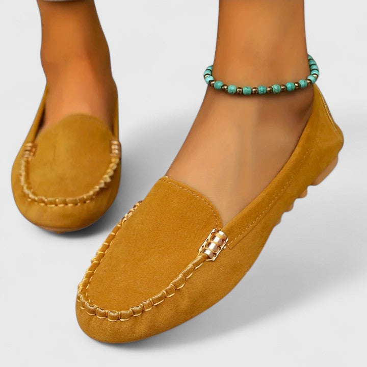 Yellow suede slip-on loafers with metal buckle detail and stitched side seams