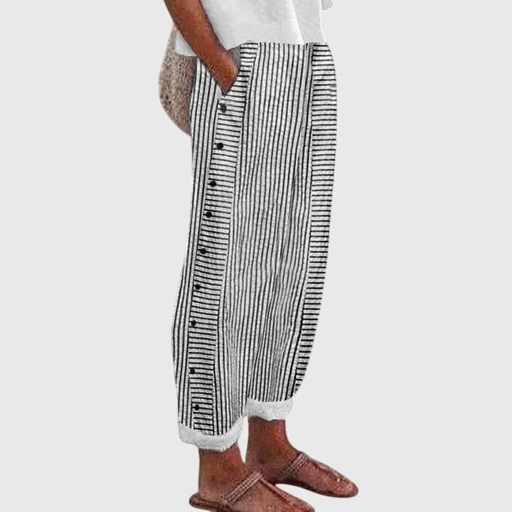 Black striped button-front pants with vertical button placket and elastic ankle cuffs
