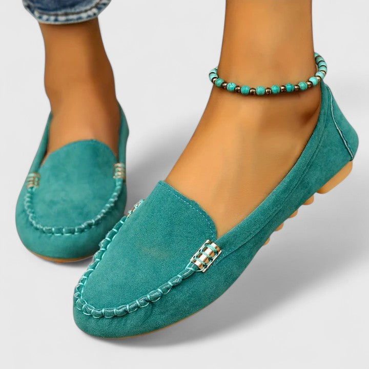 Teal suede slip-on loafers with metal buckle strap and stitched moccasin edge