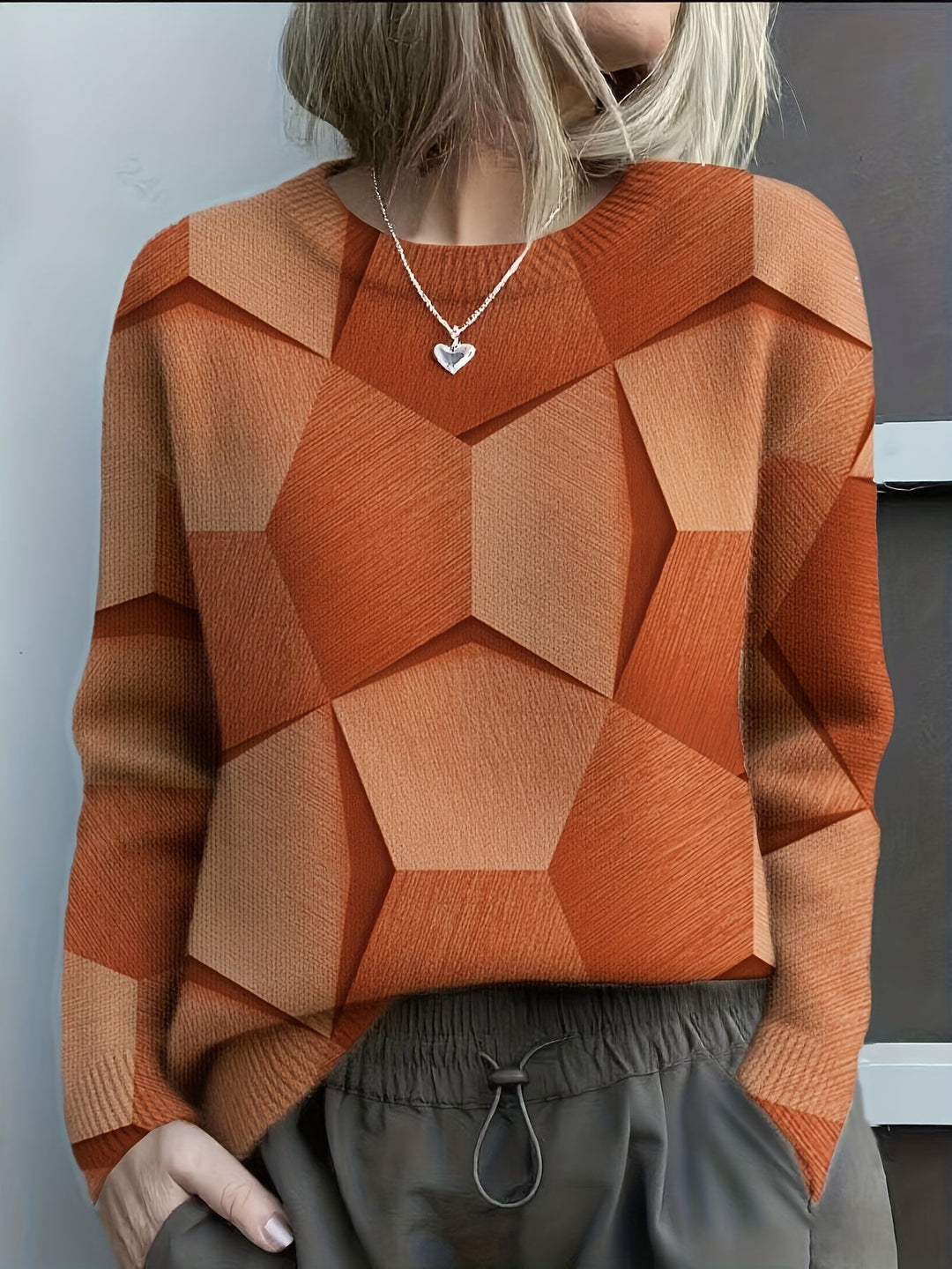 Orange geometric knit sweater with wide V-neck and long sleeves
