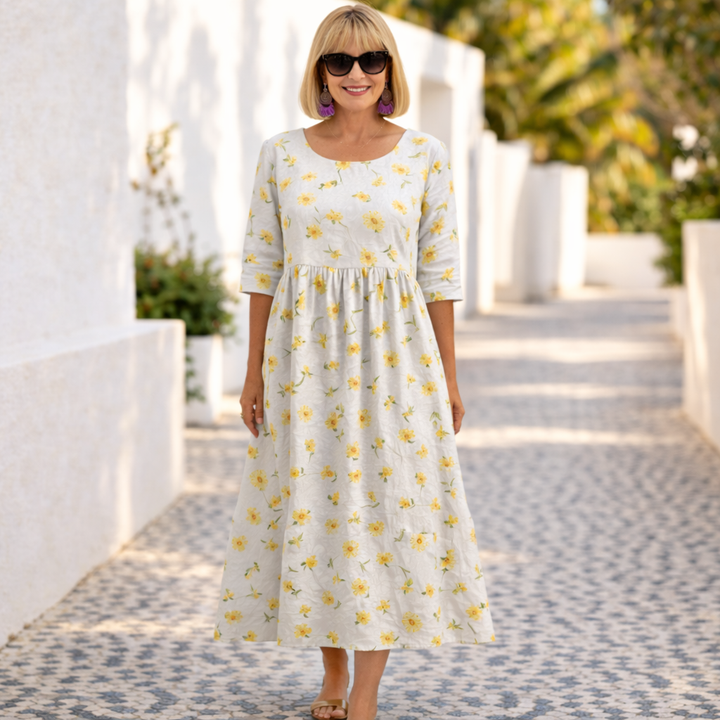 Floral dress in white with yellow flower print, three-quarter sleeves and gathered skirt