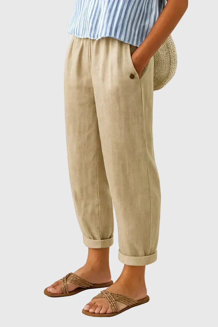 Beige relaxed pants with elastic waistband, button detail, and cuffed hems