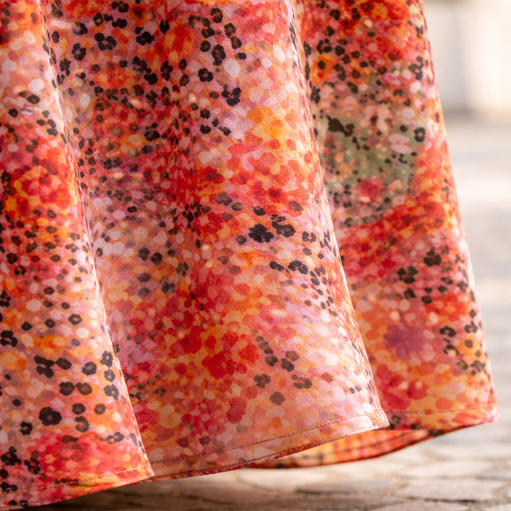 Close-up of floral midi dress fabric with multicolor speckled pattern and gathered hem