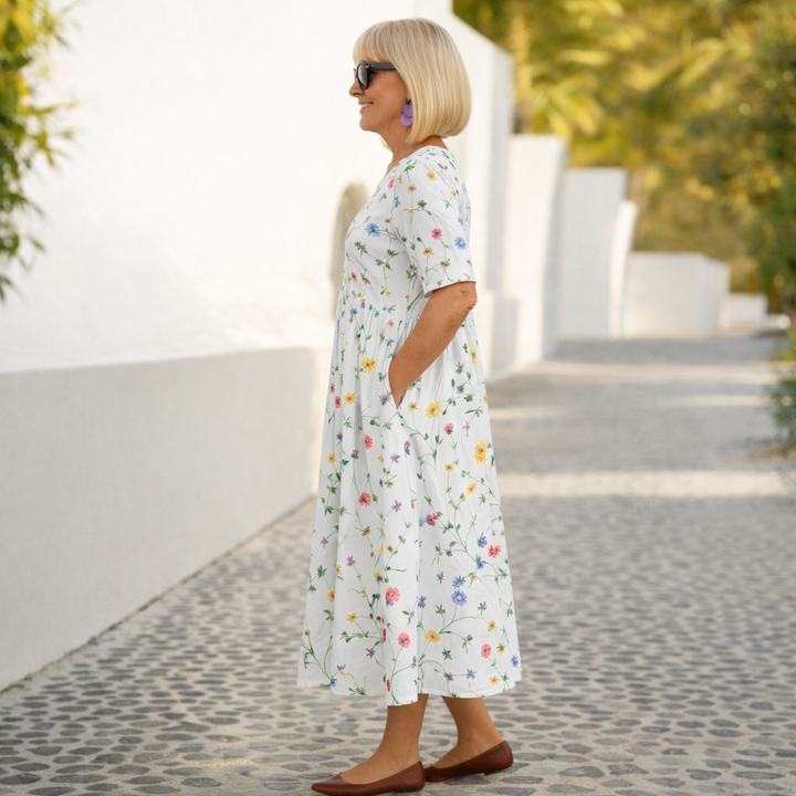 White floral midi dress with short sleeves and gathered skirt, side view