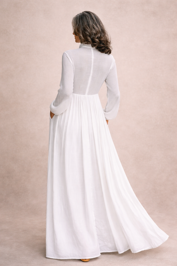 Back view of white button-front maxi dress with long sleeves and flowing skirt