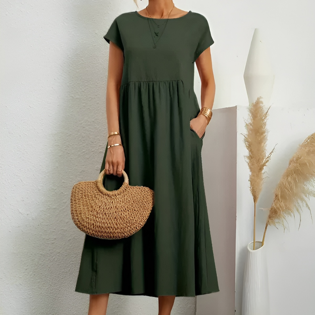 Green midi dress with short sleeves, round neck, and gathered waist with a flowy skirt.