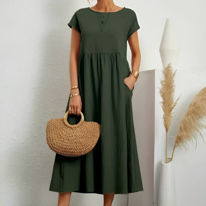 Green midi dress with short sleeves, round neck, and gathered waist with a flowy skirt.