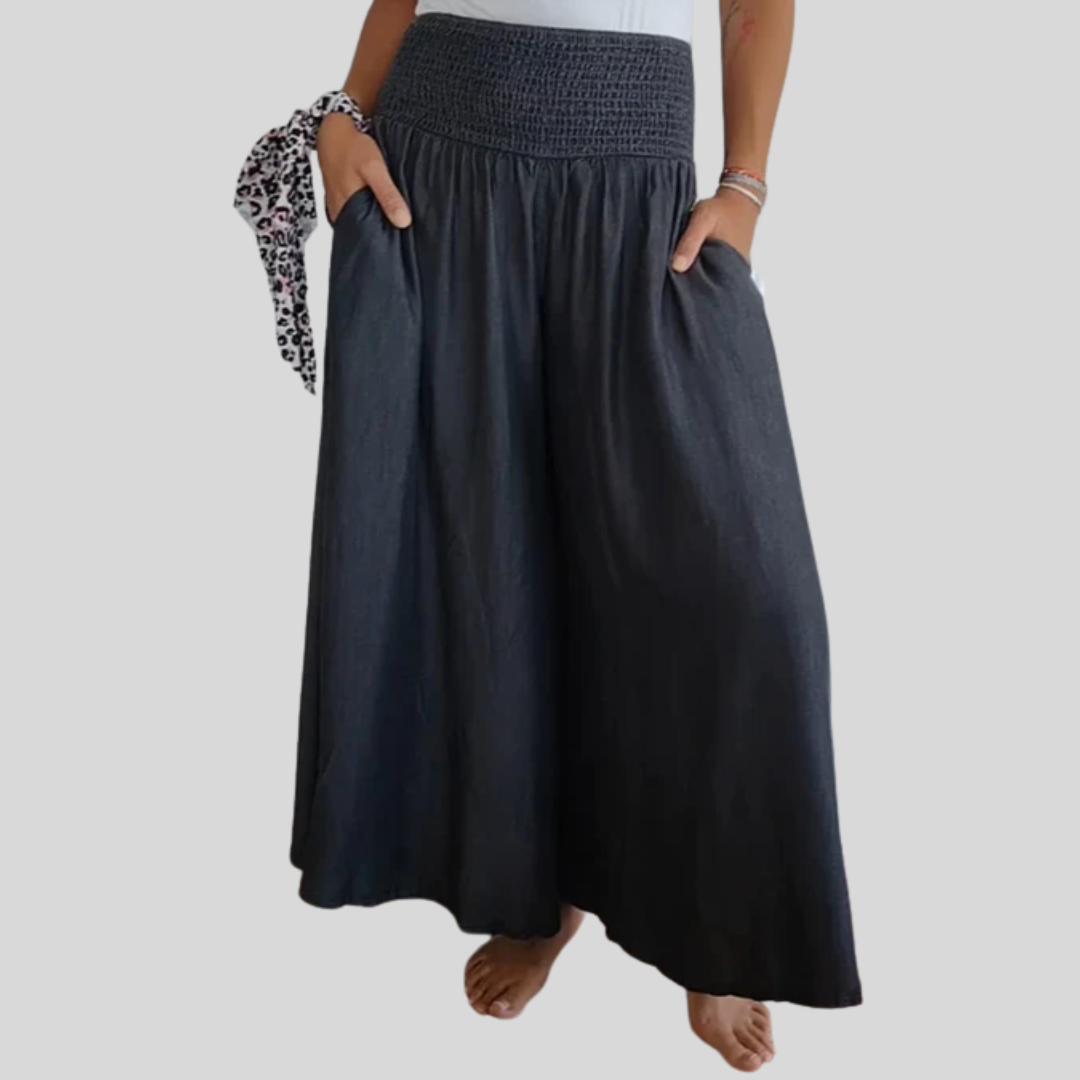Dark blue flowy wide pants with elastic smocked waistband and gathered skirt