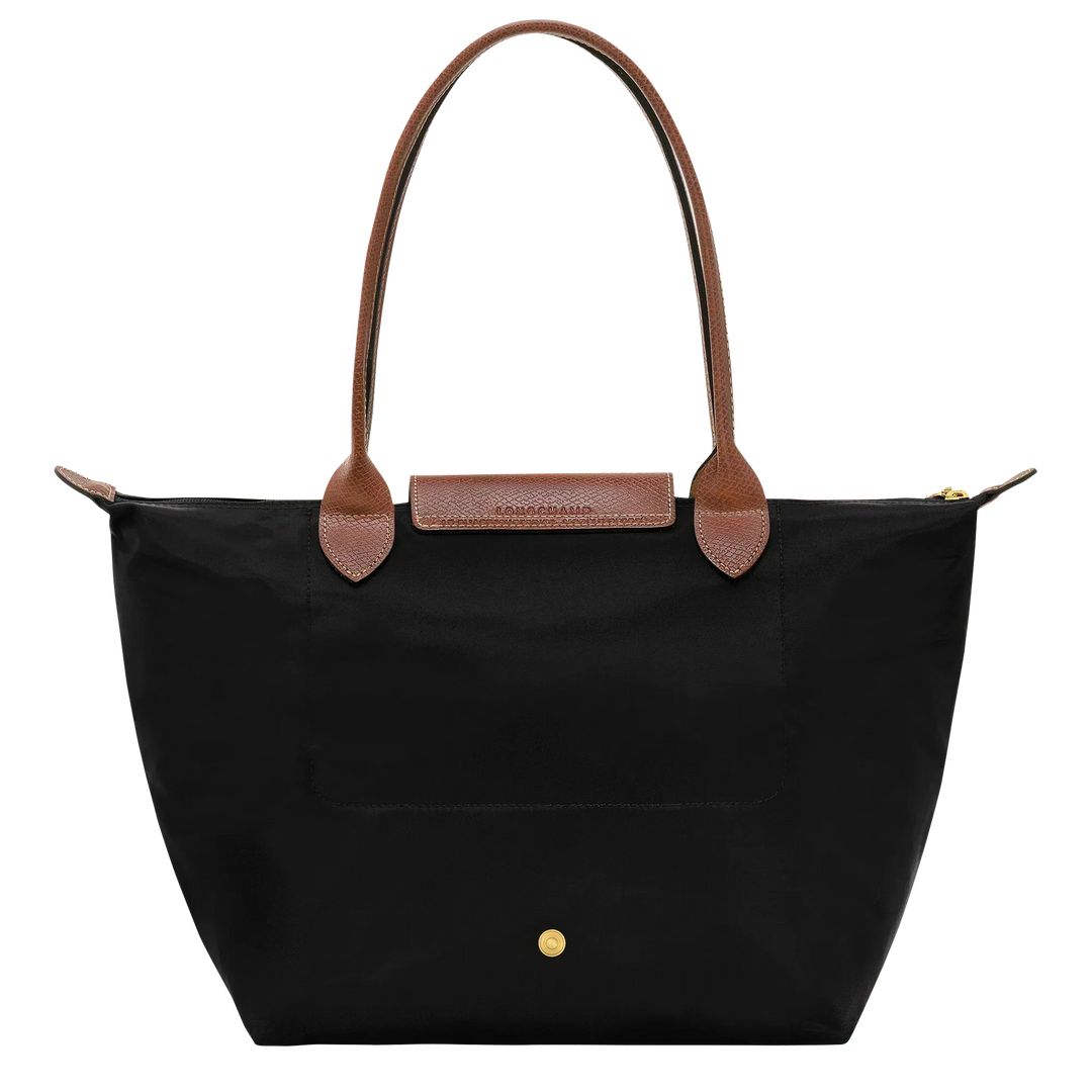Medium nylon tote bag front view with black fabric, brown handle accents, and gold snap