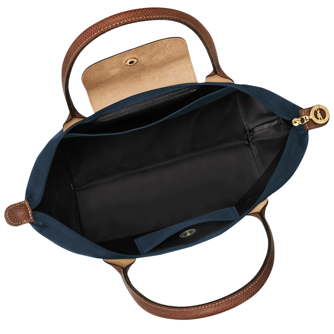Open navy nylon tote with brown leather handles, zip-top and black interior lining