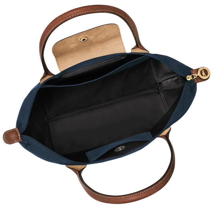 Open navy nylon tote with brown leather handles, zip-top and black interior lining