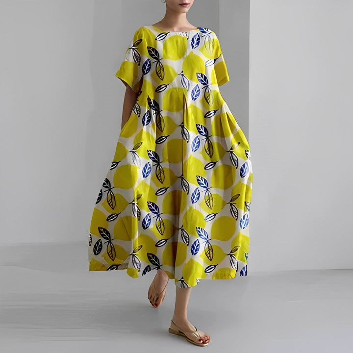 Abstract flow floral dress in bright yellow with blue leaf-like print, loose midi.