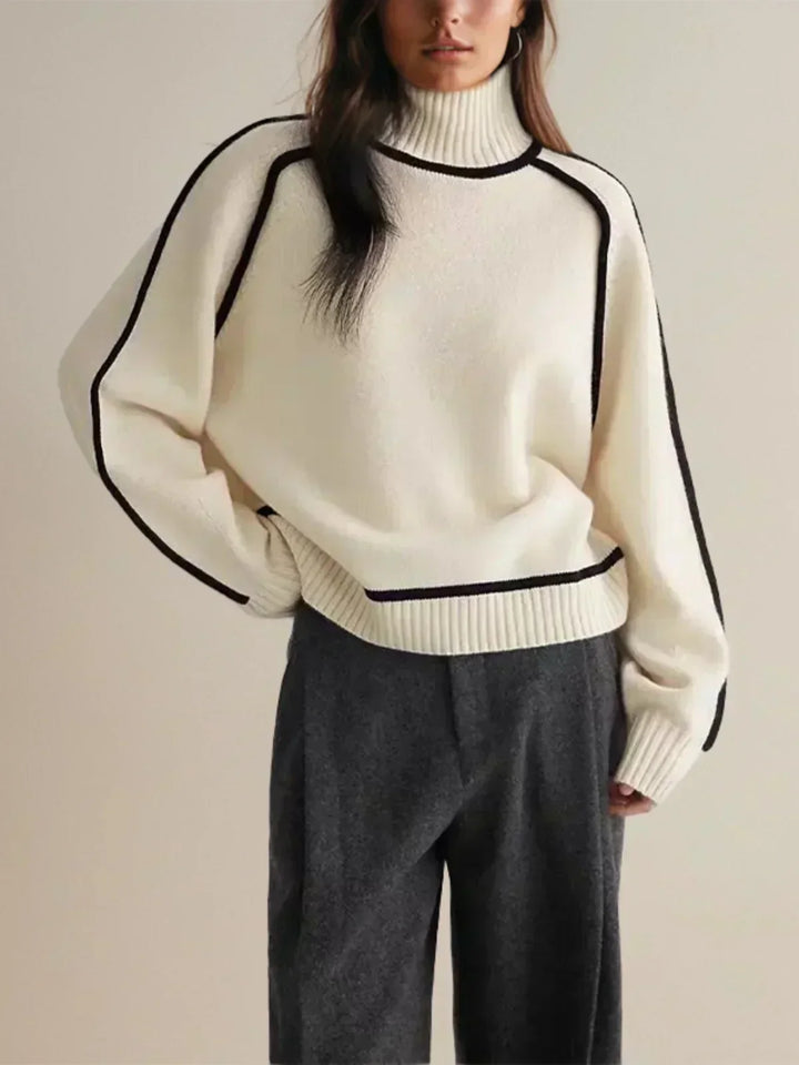 White luxe trim turtleneck sweater with ribbed collar and black trim along edges
