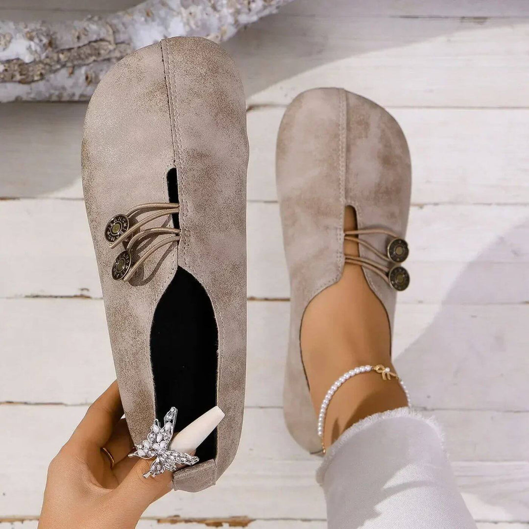 Light brown slip-on flats with lace-up front and two round button accents