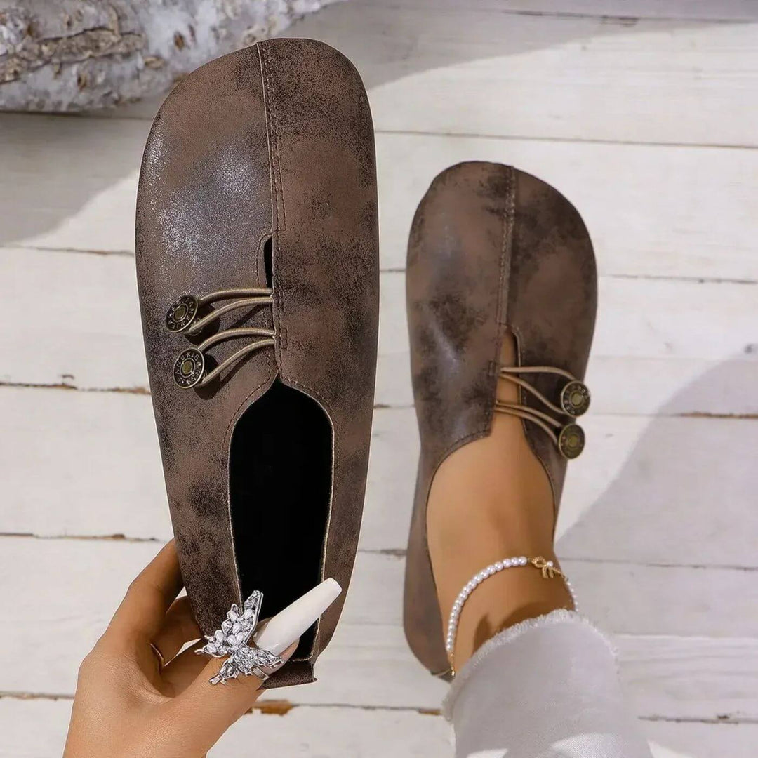 Dark brown slip-on flats with lace-up front and two round button accents