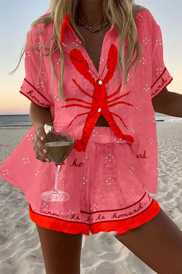 Pink coastal two-piece set with lobster print, button-front blouse and matching shorts.