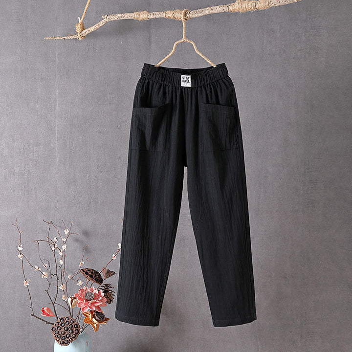 Black relaxed pocket pants with elastic waistband and two side patch pockets.