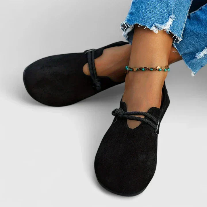 Women's black slip-on shoes with tied laces and soft fabric upper