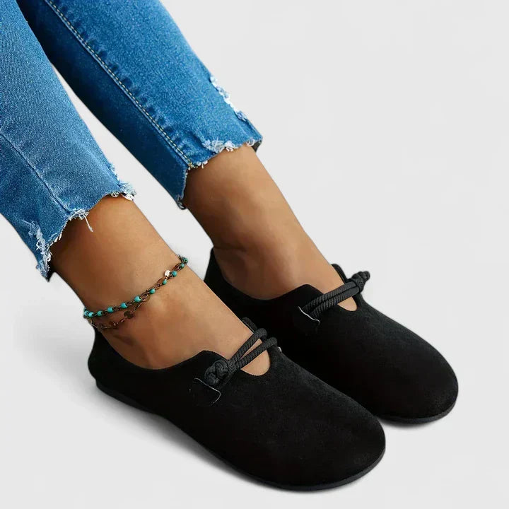 Women's black slip-on shoes with elastic lace detail and rounded toe