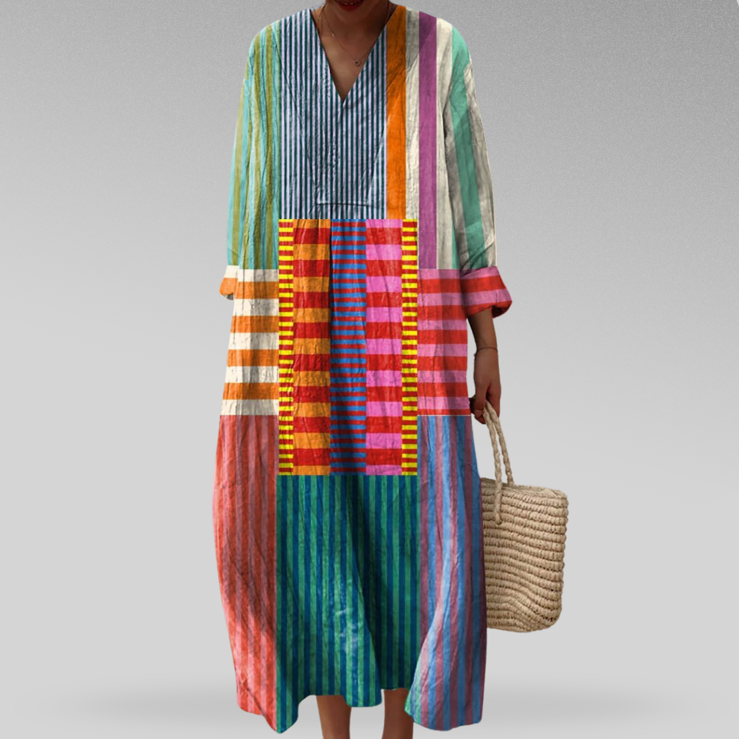 Geometric long-sleeve dress with V-neck, multicolor vertical stripes and patchwork panels.