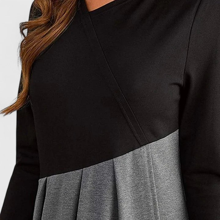 Close-up of pleated contrast maxi dress: black yoke and gray pleats at waist