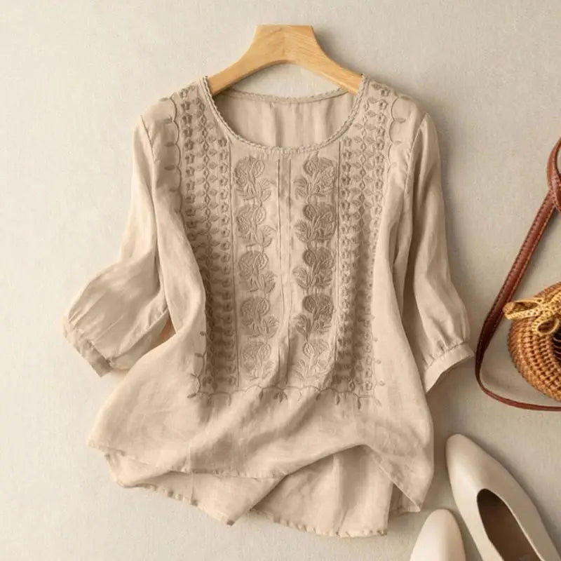 Beige embroidered blouse with vertical stitched panels and elbow-length puff sleeves