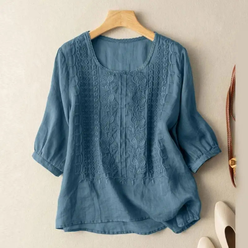 Blue embroidered blouse with vertical floral embroidery and elbow-length puff sleeves