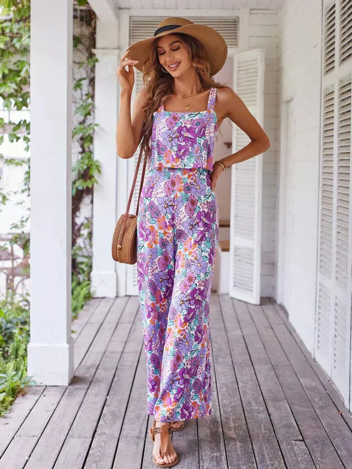 Purple floral wide-leg jumpsuit with sleeveless straps and tiered wide pants.