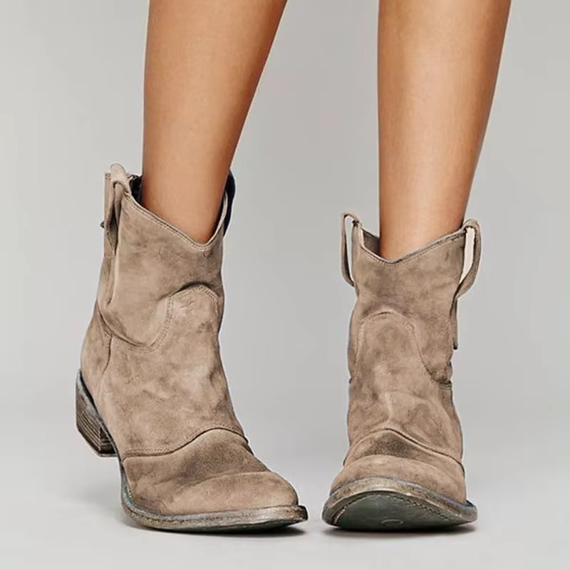 Beige suede western ankle boots with low block heel, pull tabs, and pointed toe