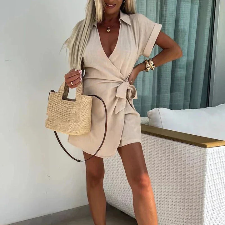Avery wrap playsuit in beige with V-neck, short sleeves, and tie waist detail.