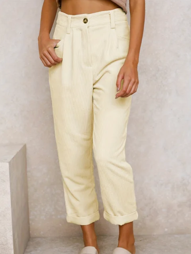 Relaxed corduroy pants in off-white with button front, side pockets, and cuffed ankle hem