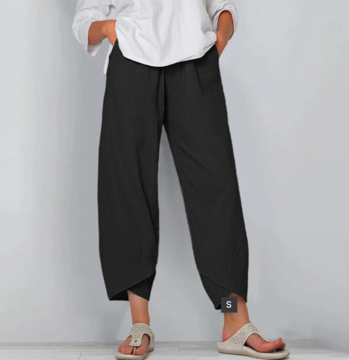 Relaxed everyday pants in black, cropped, side pockets, draped hem panels