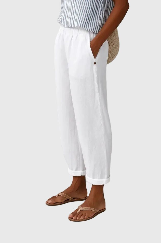 White relaxed pants with elastic waistband, button detail, and cuffed hems