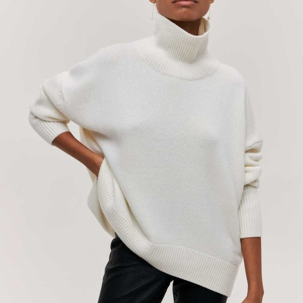White turtleneck knit sweater with ribbed collar and relaxed sleeves.