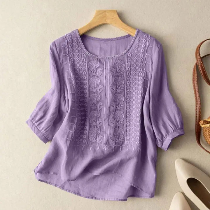 Purple embroidered blouse with vertical floral stitching and elbow-length puff sleeves