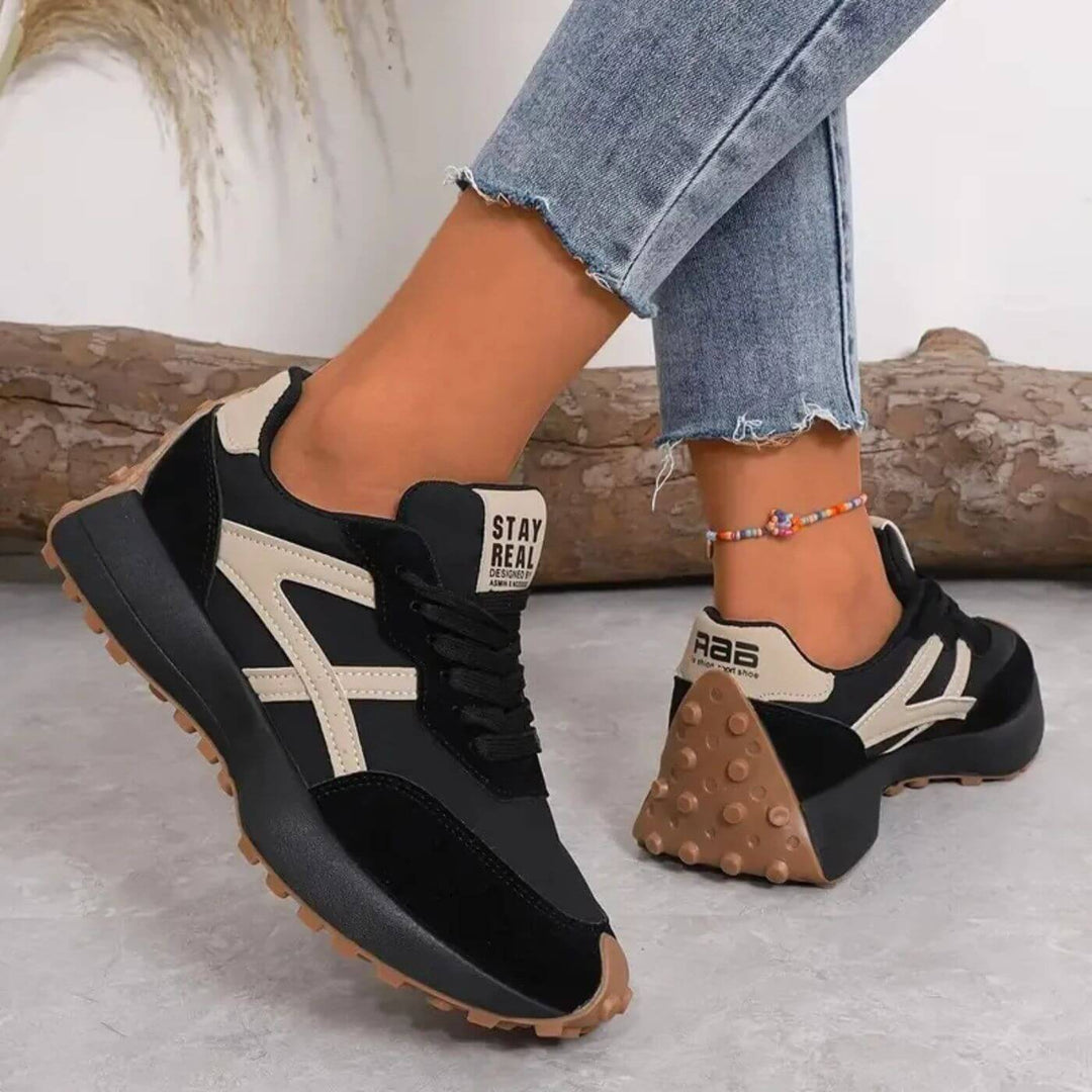Black lace-up trainers with beige stripes, chunky rubber sole, 'STAY REAL' heel tab